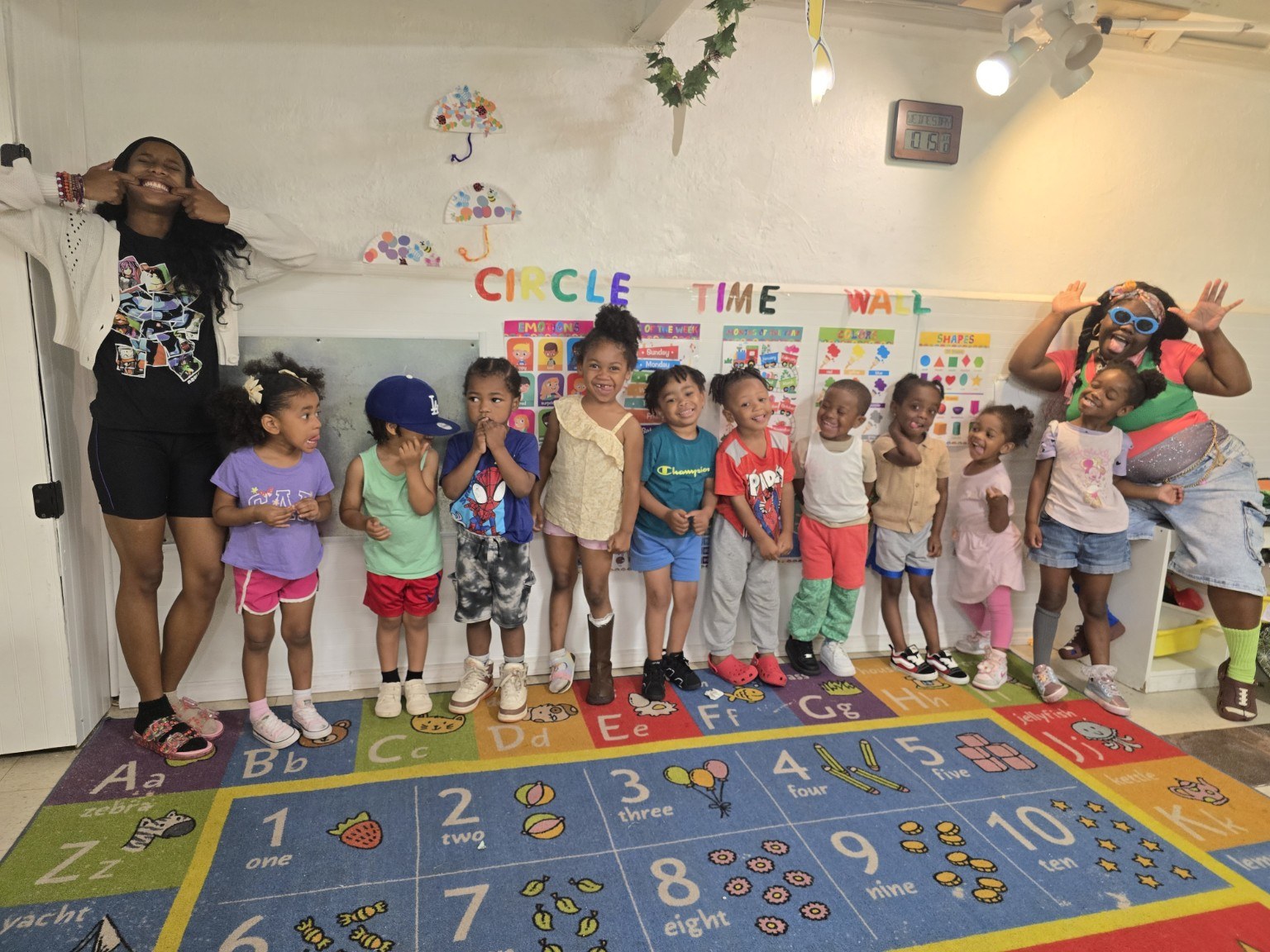 Children and teachers smiling in a Pre-K University classroom